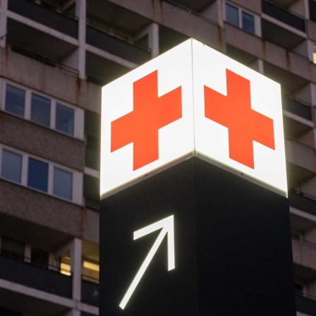 Ein Pfeil unter einem Leuchtwürfel mit rotem Kreuz auf weißem Grund weist den Weg zu einer Notaufnahme