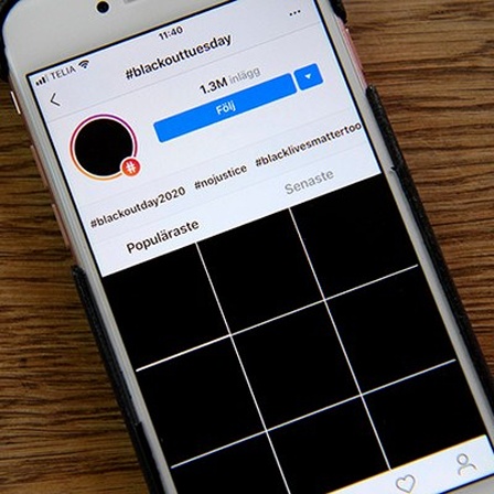 Ein Smartphone liegt auf einem Tisch, es zeigt Instagram und viele schwarze Bilder.