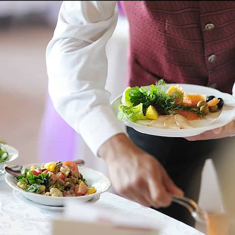 Ein Kellner serviert in einem Restaurant Essen