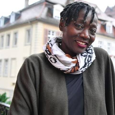 Die kenianische Autorin Auma Obama steht am 30.11.2017 in Heidelberg im Rathaus auf einem Balkon mit Blick auf das Heidelberger Schloss