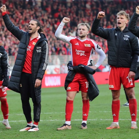 Die Spieler von Union Berlin feiern mit den Fans.