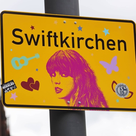 Ein Ortsschild mit der Aufschrift Swiftkirchen statt Gelsenkirchen und einem Konterfei der Sängerin Taylor Swift.