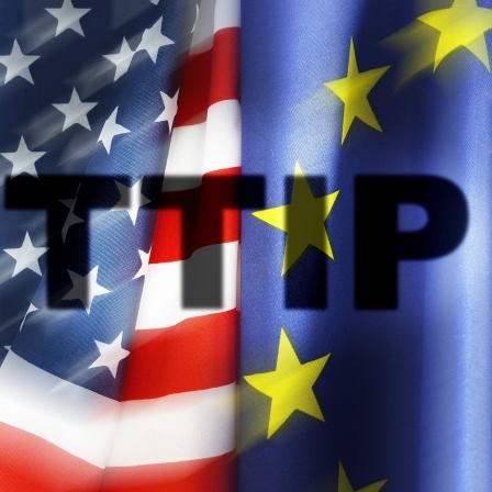 Der Schriftzug "TTIP" steht vor den Fahnen der EU der USA.