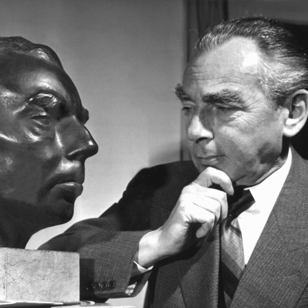 Der deutsche Schriftsteller Erich Kästner betrachtet im Jahre 1959 nachdenklich sein Ebenbild (Bild: picture alliance/dpa/Goebel)