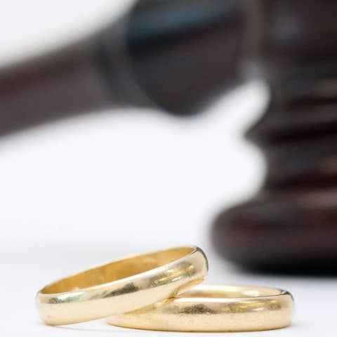 ILLUSTRATION - Zwei goldene Eheringe liegen am 11.12.2012 in Berlin vor einem Gerichtshammer.