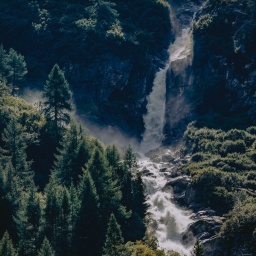 Ein tosender Floss mit Wasserfall zwischen Tannenwäldern in Osttirol, in Hohen Tauen