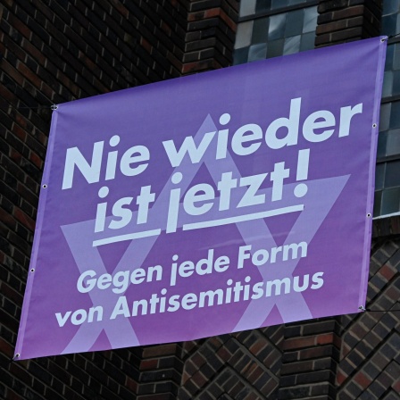 Banner mit der Aufschrift &#034;Nie wieder ist jetzt!&#034; Gegen jede Form von Antisemitismus an der katholischen St. Bonifatiuskirche in Frankfurt-Sachsenhausen.