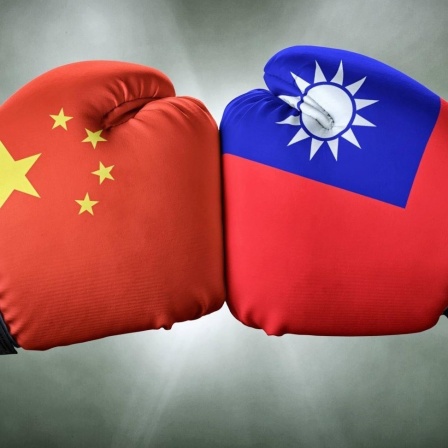 Boxkampf - China gegen Taiwan: Zwei Boxerfäuste in Handschuhen mit den jeweiligen Nationalfarben stoßen aufeinander. 