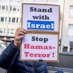 Ein Pro-Israelischer Gegendemonstrant hält zwei Plakate mit der Aufschrift "Stand with Israel - Stop Hamas-Terror!". Nach dem Terrorangriff der Hamas auf Israel kam es deutschlandweit zu zahlreichen Reaktionen.