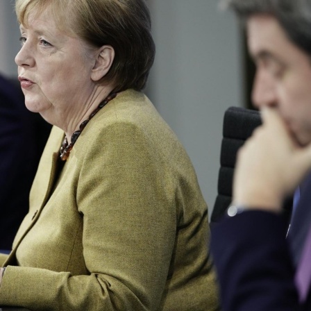 Germany's Chancellor Angela Merkel joins Markus Soeder (CSU), right, Prime Minister of Bavaria and CSU Chairman, and Michael Mueller (SPD), Governing Mayor of Berlin in a press conference following the consultations between the federal and state governmen