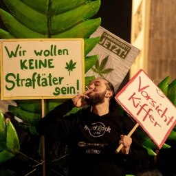 Ein Mann zieht bei einer Versammlung anlässlich der Legalisierung von Cannabis am Brandenburger Tor an einem Joint 