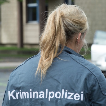 Rücken einer Frau. Sie trägt eine Jacke mit der Aufschrift: Kriminalpolizei. Bis heute gibt es bei der Kripo deutlich weniger Kolleginnen als Kollegen. Auch, weil ermittelnde Polizistinnen lange mit dem Vorurteil zu kämpfen hatten, Frau-Sein und Staatsgewalt passten nicht zusammen.