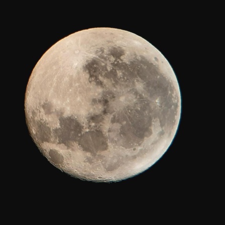 Ein fast voller Mond am schwarzen Nachthimmel.
