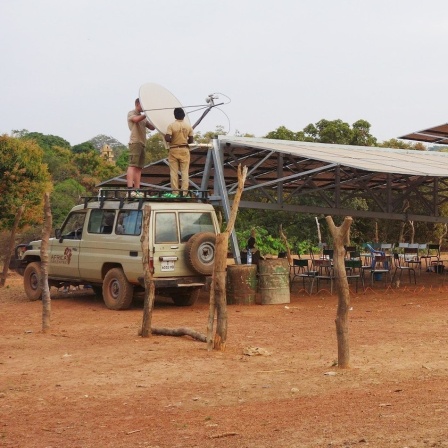 Ein Solartainer, mit dem Strom aus Sonnenenergie gewonnen wird, steht in einem Dorf.
