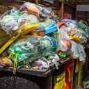 Überfüllte Müllcontainer stehen in einem Hinterhof