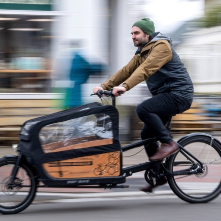 Ernst Schäfer, Mitbegründer des Lastenradverleihs "Rädchen für alles", fährt auf einem Lastenrad durch die Innenstadt von Oldenburg.