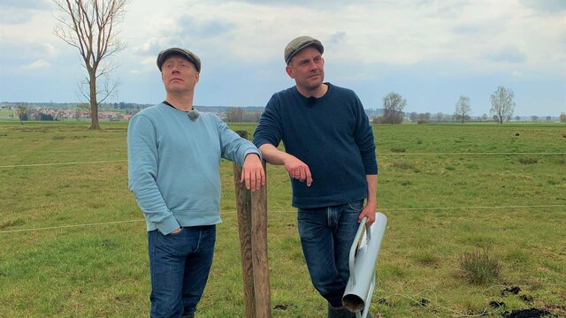 Von links: Simon Schwarz und Sebastian Bezzel lehnen an einem Zaun. | Bild: BR/strandgutmedia GmbH/Benjamin Frank