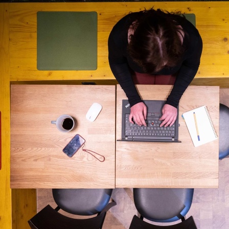 Eine Frau sitzt im Homeoffice am Küchentisch