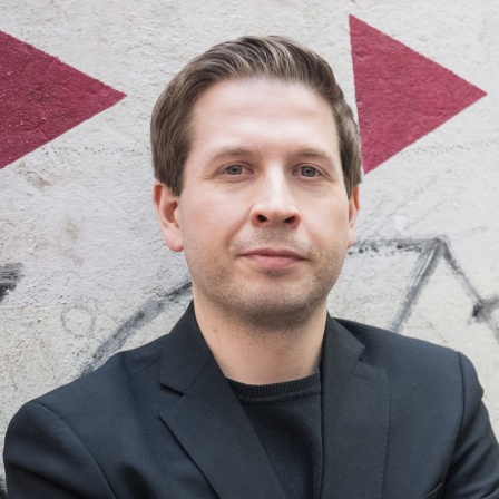SPD-Generalsekretär Kevin Kühnert steht vor einer Wand