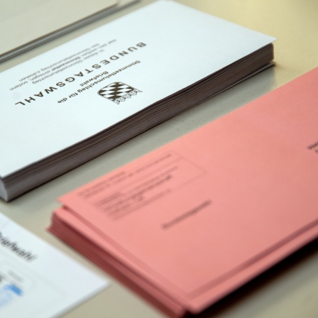 Umschläge und Merkblätter für die vorgezogene Neuwahl zum 21. Deutschen Bundestag liegen auf einem Tisch.