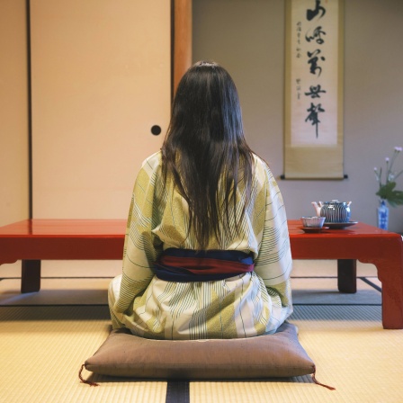 Frau in Japan sitzt auf dem Boden an einem Tisch