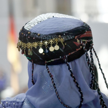 Symbolfoto: Ein Mitglied des Zentralrats der Jesiden trägt bei einer Veranstaltung im Deutschen Bundestag ein traditionelles Gewand mit Kopfschmuck.