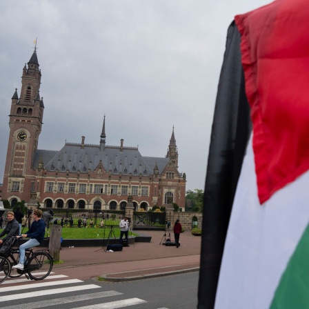 Ein Demonstrant schwenkt die palästinensische Fahne vor dem Friedenspalast in Den Haag (Niederlande), in dem der "Internationale Gerichtshof der Vereinten Nationen" untergebracht ist.