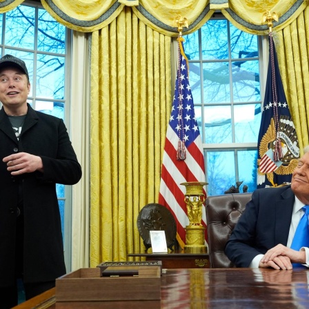 US-Präsident Donald Trump (r) hört zu, als Elon Musk im Oval Office im Weißen Haus spricht. 