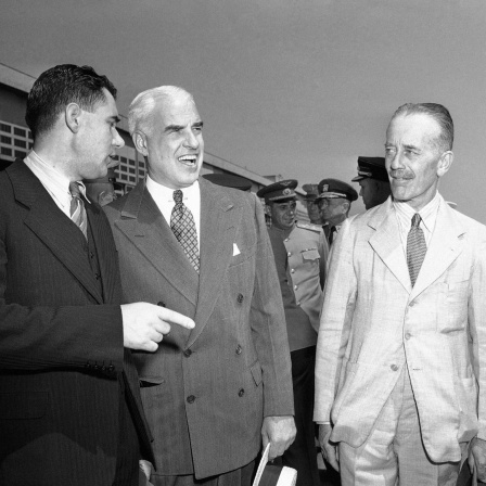 Drei Männer stehten beisammen und unterhalten sich. Der Mann in der Mitte lacht. Es sind die Delegierten der Sowjetunion, Großbritanniens und der USA für die Gespräche in Dumbarton Oaks.