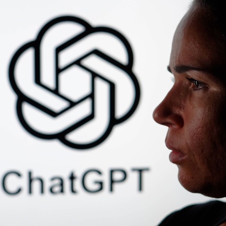 Frau hält ein Smartphone in der Hand, im Hintergrund das Logo von ChatGPT