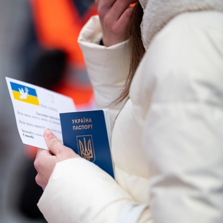 Eine junge Frau aus der Ukraine mit ihrem Pass in der Hand in Hamburg.