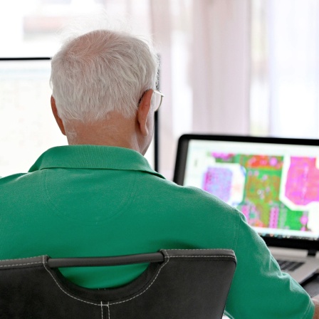 Ein Senior arbeitet in seiner Elektronik-Werkstatt im Home-Office.