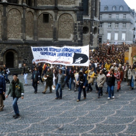 Demonstranten tragen ein Transparent mit der Aufschrift "Gegen die atomare Bedrohung gemeinsam vorgehen".