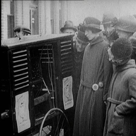 Menschen, die sich um ein großes Funkgerät im Freien versammeln, 1922.