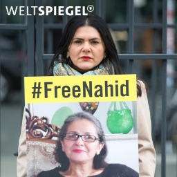 Mariam Claren demonstriert für die Freiheit ihrer Mutter Nahid Taghavi und hält dazu ein Schild mit dem Hashtag #freenahid.