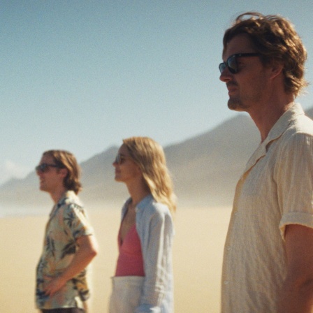 Szene aus dem Film "Islands": Vier Personen stehen am Strand und blicken aufs Meer