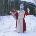 Nikolaus steht mit Sack voller Geschenke im Schnee