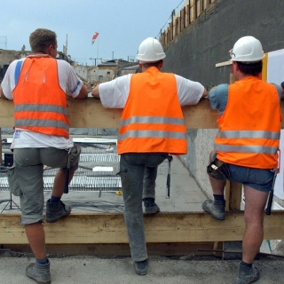 Bauarbeiter stehen am Erfurter Hauptbahnhof vor einer Baugrube