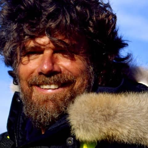 Bergsteiger Reinhold Messner mit dicker Jacke, langen Haaren und dichtem Vollbart.