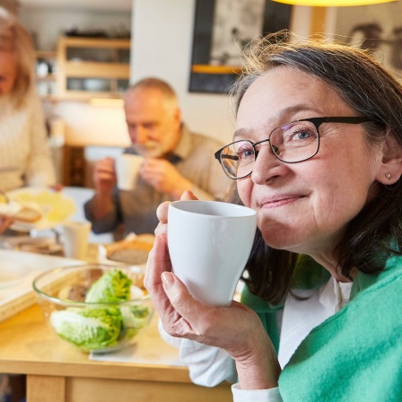 Senioren sitzen zusammen in der Küche und frühstücken.