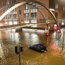 Ein Auto steht in der Speicherstadt, während einer Sturmflut im Hochwasser der Elbe im Wasser.