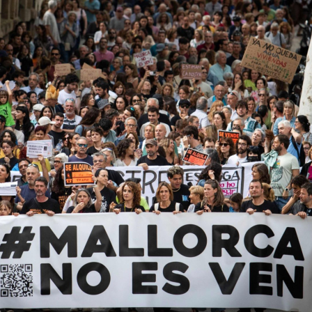 Eine große Demonstration auf einer Straße in einer Stadt auf Mallorca. Hunderte von Menschen nehmen an dem Protest teil und tragen Plakate und Banner mit verschiedenen Botschaften, die sich gegen den Ausverkauf der Insel richten.