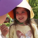 Kinder tragen selbst gebastelte Sonnenhüte aus bunter Pappe.