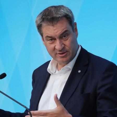 Markus Söder (CSU) steht bei einer Pressekonferenz an einem Pult vor einer blauen Wand.