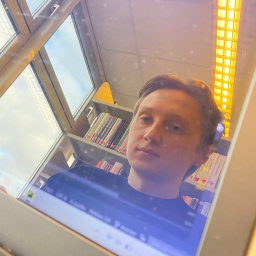 Student Tom Tlok spiegelt sich im Bildschirm seines Computers.