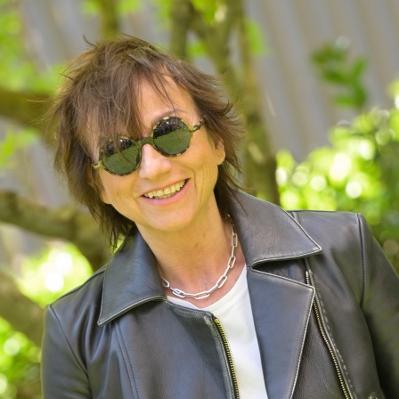 Gianna Nannini mit Sonnenbrille und Lederjacke im Grünen (2022).