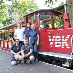 Menschen stehen vor der Schlossgartenbahn Karlsruhe. Die Bahn fährt am Bundesverfassungsgericht.