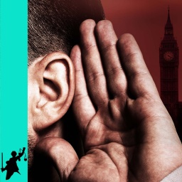 Ein Mann hält seine Hand an sein Ohr, hinter ihm ist das Parlamentsgebäude in London zu sehen.