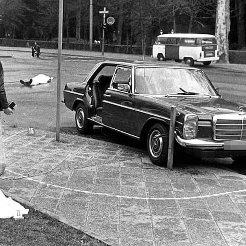 ARCHIV - Der Tatort mit den zugedeckten Leichen von Siegfried Buback (vorne links) und seines Fahrers sowie der Dienstwagen des Generalbundesanwaltes in Karlsruhe