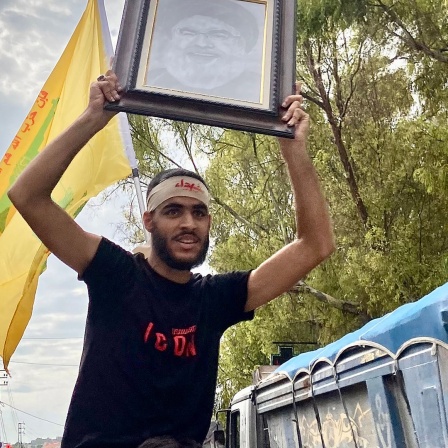 Hisbollah-Anhänger bei einer Demonstration gegen Israel hält ein Porträt hoch (Libanon).